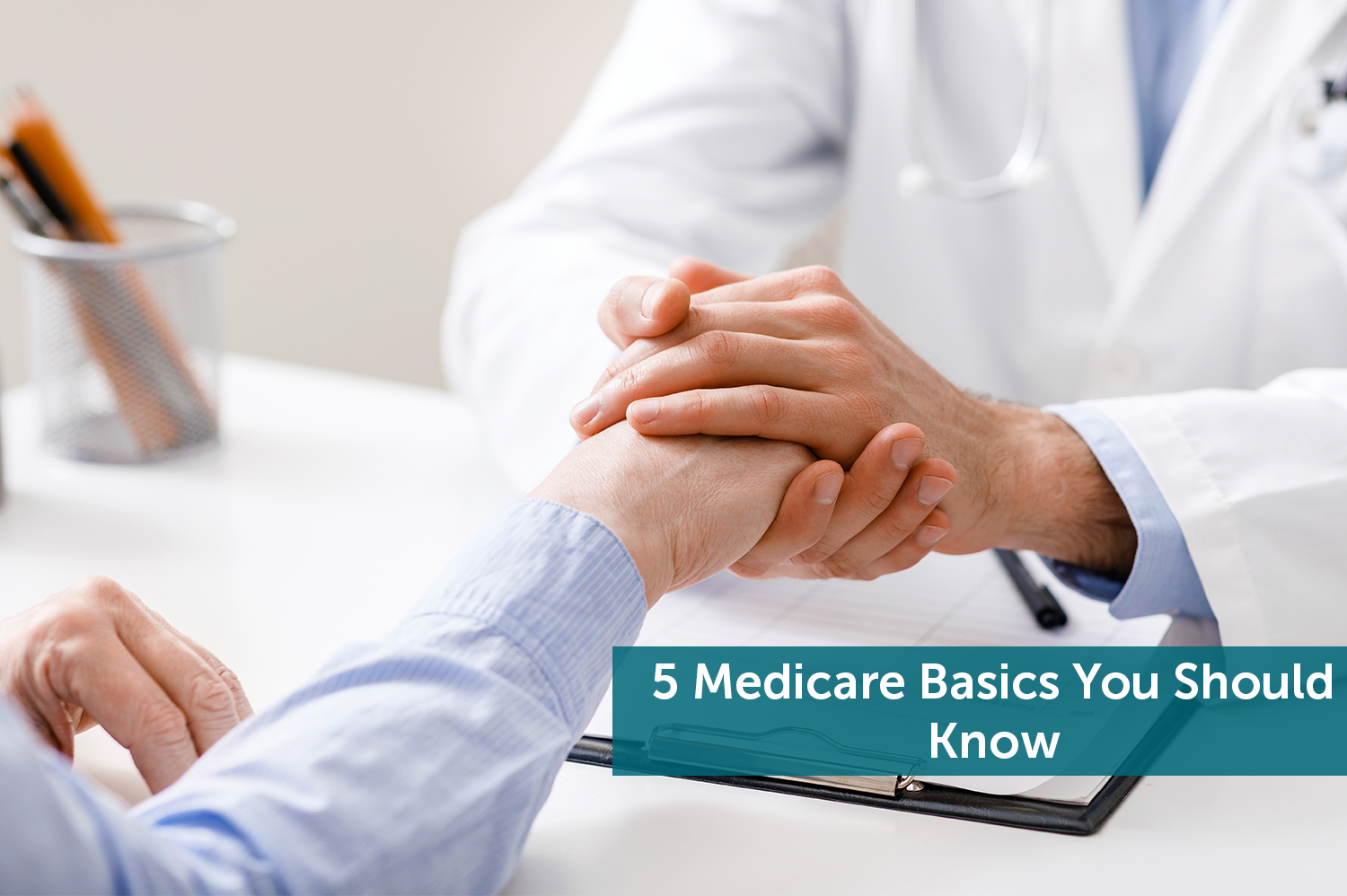 Doctor going over Medicare basics in office while holding his hand.