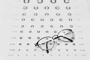 Pair of eyeglasses sitting on top of black and white eye exam. 