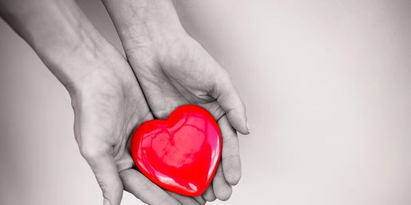 Caring hands holding heart