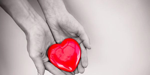Hand holding heart Caring hands holding heart