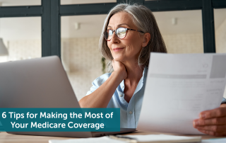 A senior woman looking at her computer and Medicare coverage, smiling.