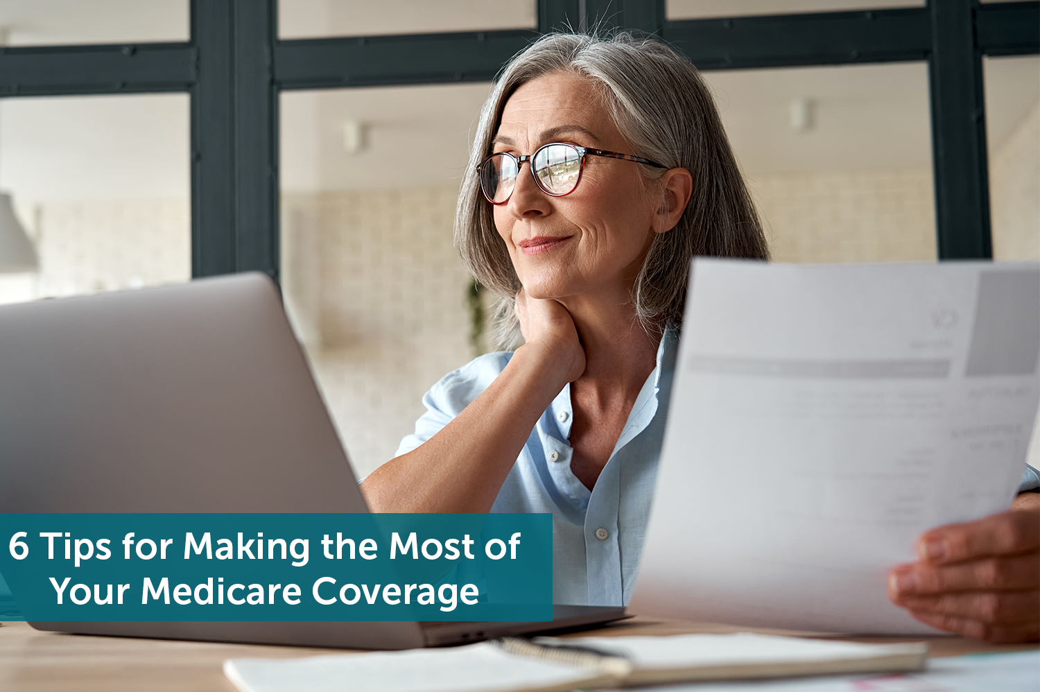 A senior woman looking at her computer and Medicare coverage, smiling.